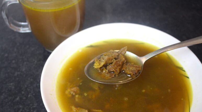 Desi Yakhni (Mutton Broth) served in a bowl with tender mutton pieces and aromatic spices.