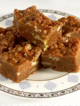 Habshi Halwa topped with almonds and pistachios on a serving tray