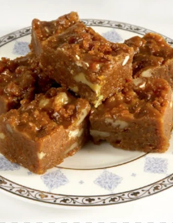 Habshi Halwa topped with almonds and pistachios on a serving tray