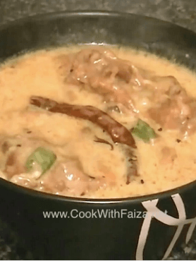 Authentic Pakistani Kadhi Pakora - golden crispy fritters in creamy yellow yogurt curry, garnished with fresh coriander, served in a brass bowl with rice