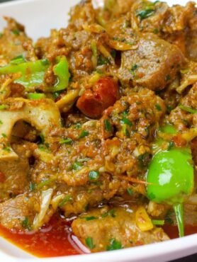 Khada Masala Mutton Karahi served in a handi with green chillies and coriander on top