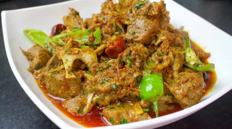 Khada Masala Mutton Karahi served in a handi with green chillies and coriander on top