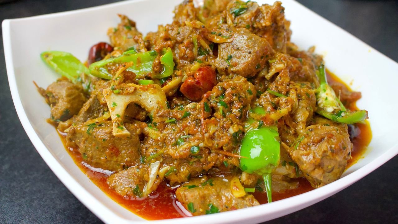 Khada Masala Mutton Karahi served in a handi with green chillies and coriander on top
